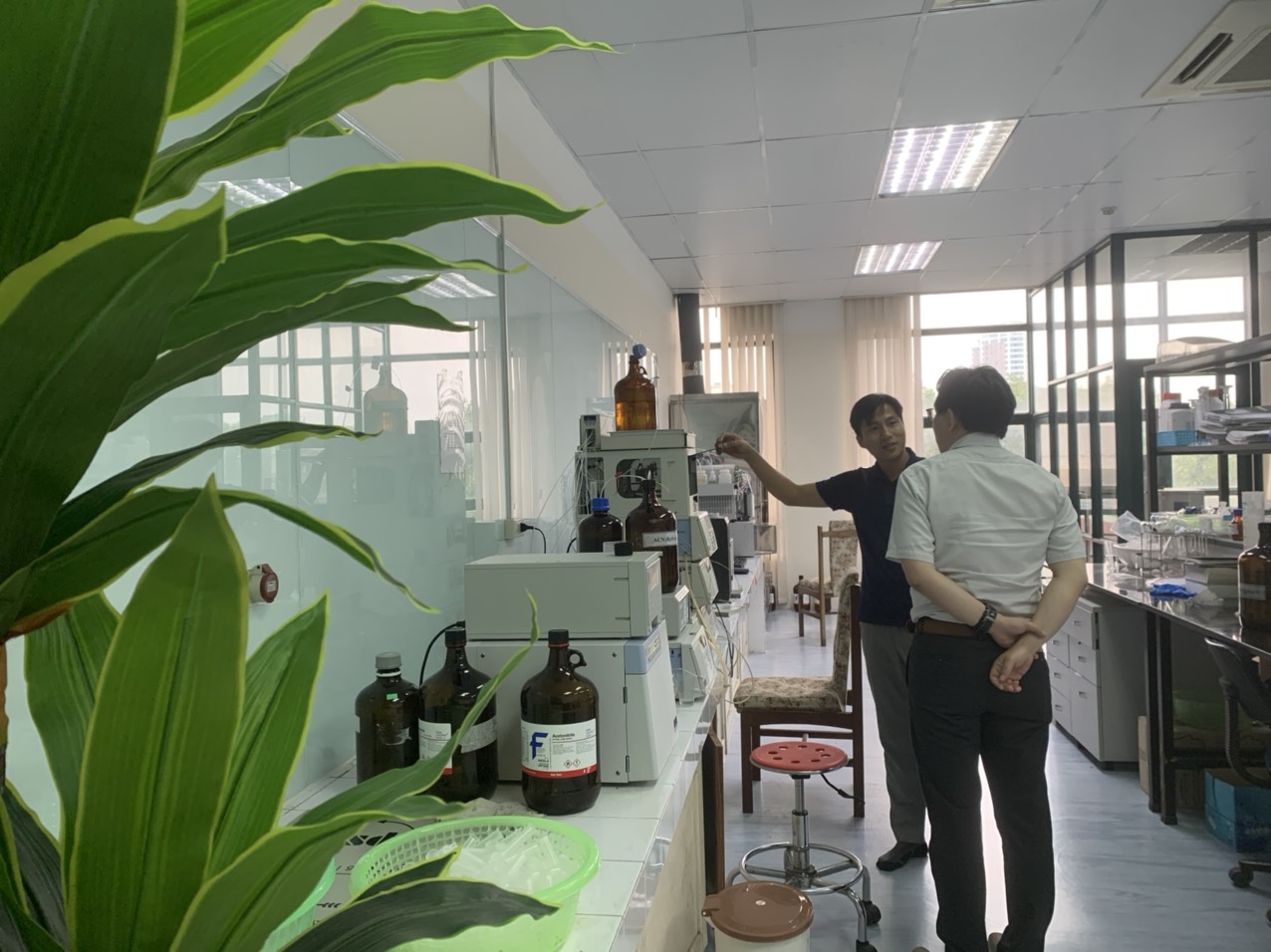 Cán bộ của Trạm giải thích quy trình vận hành Hệ thống sắc ký lỏng hiệu năng cao HPLC